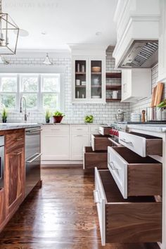 a kitchen with wooden floors and white cabinets