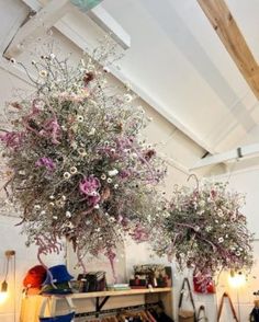 two vases with flowers hanging from the ceiling in a room filled with shoes and other items