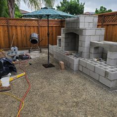 an outdoor fireplace is being built in the back yard