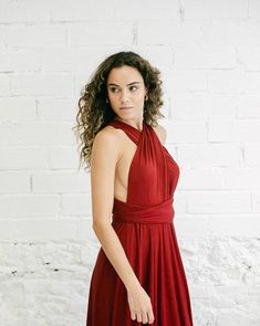 a woman in a red dress is posing for the camera