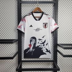 a soccer jersey hanging on a rack in front of a fence with birds flying around it