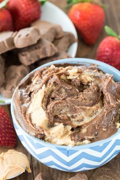 chocolate peanut butter dip in a blue bowl with strawberries and cookies on the side