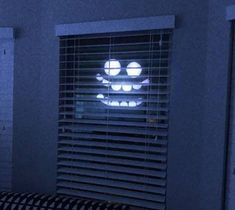 a window with the blinds open and a lit up smiley face on it's side