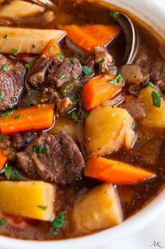 a white bowl filled with stew and carrots