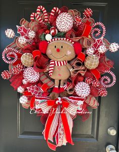 a wreath with a gingerbread man and candy canes hanging on the front door