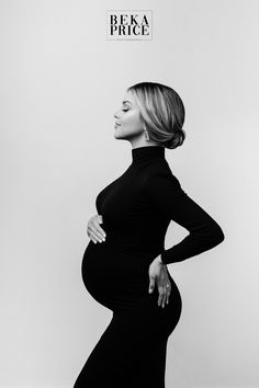 a pregnant woman poses for a black and white photo with her hands on her hips