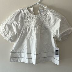 Our Armande Top Is The Fresh Pick Of The Season. The Bight White Top Has Puff Shoulders, A Smocked Neck Yoke, And Tiered Hem. Pair Armande With Your Favorite Denim For A Simple, Yet Put Together, Look. White Twill Self: 100% Cotton Unlined Shank Button At Back Of Neck Stretchy, Elastic Smocking Dry Clean Only Imported, India Model Is 5'9" And Wears A Size X-Small White Casual Puff Sleeve Top With Smocked Back, Casual White Puff Sleeve Top With Smocked Back, Classic Fitted Puff Sleeve Top For Summer, Chic White Top With Smocked Back, Elegant Spring Puff Sleeve Top With Smocked Back, Elegant White Top With Smocked Bodice, Summer White Blouse With Smocked Bodice, White Puff Sleeve Top With Smocked Back For Summer, White Puff Sleeve Blouse With Smocked Back