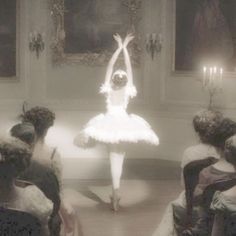 a ballerina is dancing in front of an audience