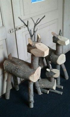 two wooden reindeer sculptures sitting next to each other on a blue carpeted floor in front of a white door