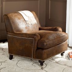 a brown leather chair sitting on top of a white rug