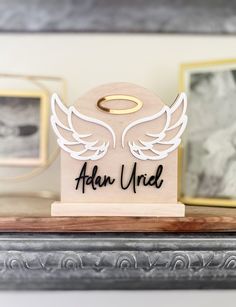 a wooden sign with angel wings on it