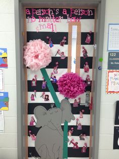 a door decorated with pink flowers and an elephant holding a flower in it's trunk