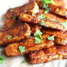 chicken wings with sauce and parsley next to a fork