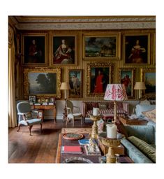 a living room filled with furniture and paintings on the wall