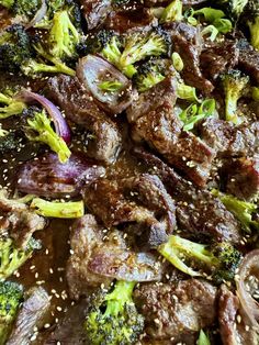 beef and broccoli stir fry with sesame seeds in a skillet, ready to be eaten