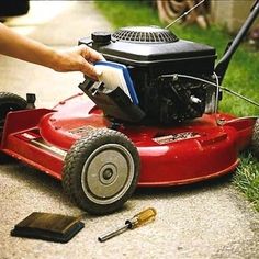 a man is cleaning his lawn mower on the sidewalk