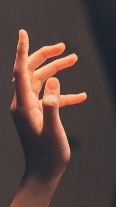 a person holding their hand up in the air with two fingers extended to one another