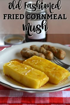 two pieces of fried cornmeal on a white plate with a fork next to it