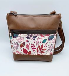 a brown and white purse with flowers on it