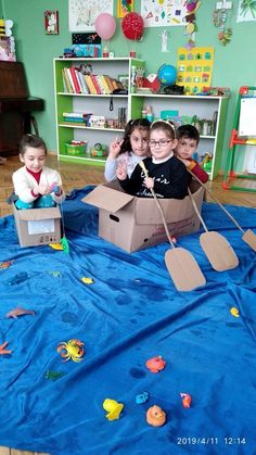 four children are playing in a cardboard boat