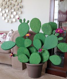 a green cactus plant sitting on top of a potted plant in front of a couch