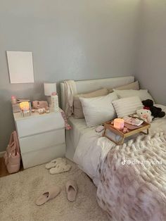 a white bed sitting in a bedroom next to a night stand and dresser with two teddy bears on it