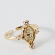 This Weisinger Designs Virgin Mary Ring is crafted from golden-plated metal for a quality finish and long-lasting shine. The front of the ring displays four cubic zirconia stones, adding a sparkling touch to the classic religious jewelry design. Virgin Mary Ring, Gold Diamond Promise Ring With Stone Setting, Gold Crystal Open Ring With Stone Setting, Gold Diamond Crystal Ring With Stone Setting, Gold Open Diamond Ring With Stone Setting, Gold Cubic Zirconia Crystal Ring With Stone Setting, Gold Crystal Ring With Cubic Zirconia Stone Setting, Ring Displays, Christmas Items