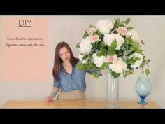 a woman arranging flowers in a vase on top of a wooden table with the words diy written above it