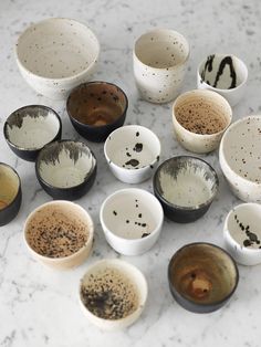 many different bowls are sitting on the table together, with one being filled with black and white stuff