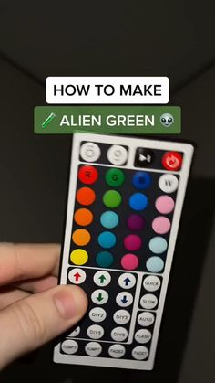 a hand holding a remote control with the words how to make alien green on it