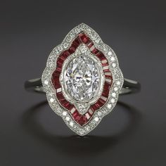 a diamond and ruby ring on a black surface with white diamonds around the center, surrounded by red garnets