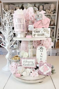 a cake stand with pink and white decorations