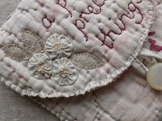 a close up of a piece of cloth with flowers on it and a bead in the middle