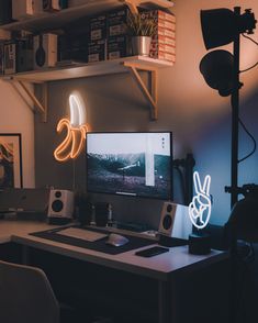 a computer desk topped with a monitor and keyboard next to a light up bunny head