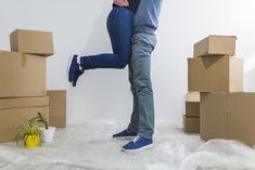 a man and woman standing in front of cardboard boxes with one holding the other's back