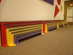 a row of benches sitting next to each other in a room with carpeted flooring