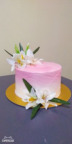 there is a pink cake with white flowers on the top and yellow trim around it