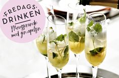 three champagne flutes filled with ice and garnished with mint leaves, sitting on a silver platter