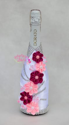 a white bottle decorated with pink and purple flowers