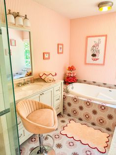 a bathroom with pink walls and flooring has a bathtub, sink, and mirror