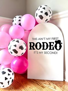 pink and white balloons are on the floor next to a sign that says, this isn't my first rodeo it's my second