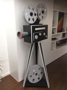 an old fashioned movie projector on display in a room with wood floors and white walls