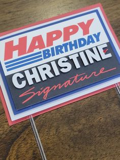 a sign that says happy birthday, christine signature on top of a wooden table