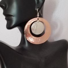 Hammered sterling silver and copper earrings which I make in 2 sizes by punching a hole in the copper disc which I hand hammer and hang a smaller hammered sterling silver disc in the cutout. They are on sterling silver ear wires. The medium size is 1&1/2 inches in diameter with a 1 inch cutout with a 3/4 inch silver disc, and the large is 2 inches with a 1 inch sterling disc. Shipped in a gift box to protect during shipment. Hammered Silver Earrings Made Of Copper, Hammered Silver Copper Earrings, Silver Hammered Copper Earrings, Hand Forged Silver Copper Earrings, Hammered Rose Gold Copper Earrings, Hand Forged Copper Hoop Earrings In Silver, Rose Gold Hammered Metal Earrings, Silver Electroformed Earrings, Hammered Copper Earrings