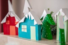 paper houses are lined up on a shelf