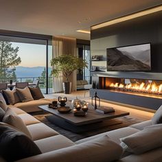 a living room filled with furniture and a fire place in front of a large window