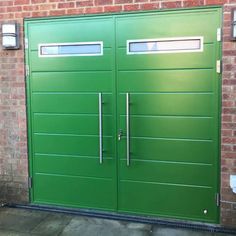 a green double door in front of a brick wall