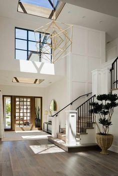 an open floor plan with wood floors and skylights above the staircase leading up to the second floor