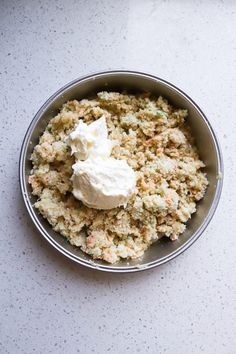 a bowl filled with food sitting on top of a white counter next to a knife