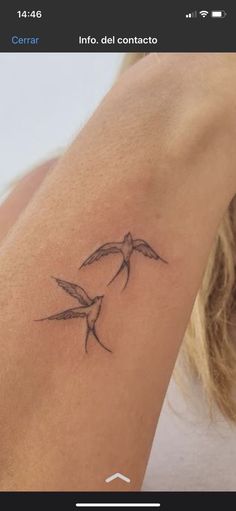 a tattoo on the arm of a woman with two birds flying over her shoulder and behind her head